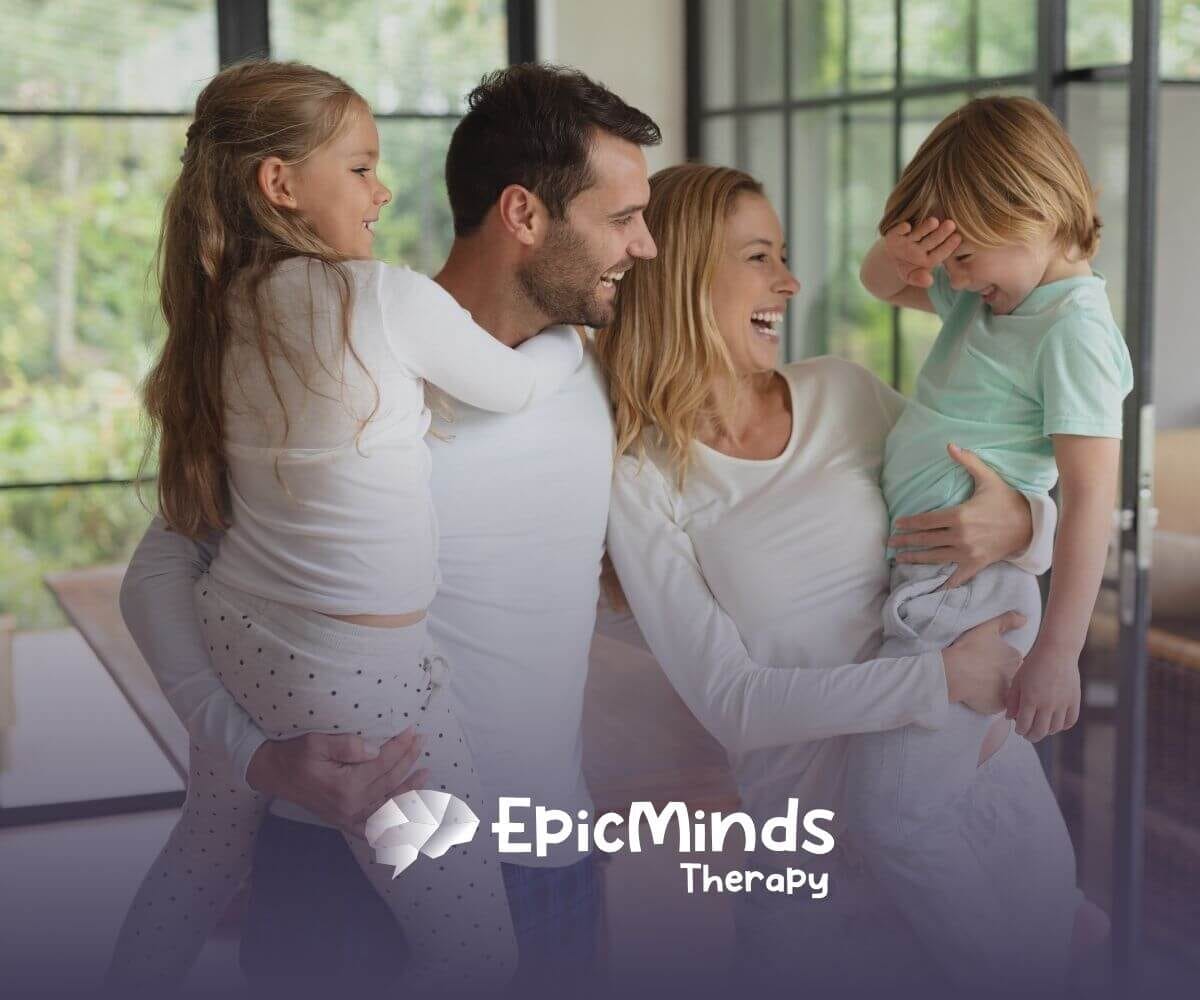 Family of four laughing and enjoying together before ABA therapy begins.