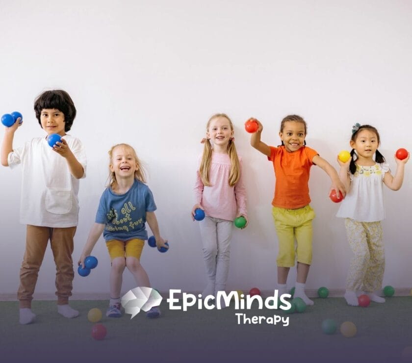 Group of smiling autistic children holding colorful balls in a playful indoor space during ABA therapy in NC.