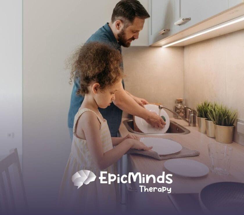 An ABA therapist and autistic child washing and drying dishes together in the kitchen during in-home ABA therapy in NC.