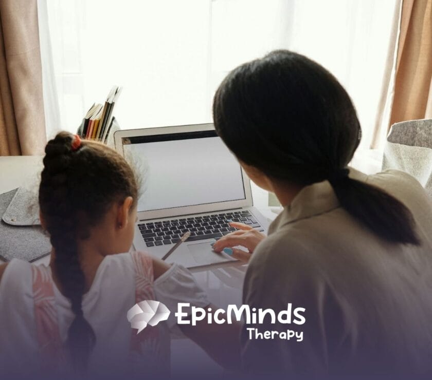 An autistic child and RBT using a laptop at a table to learn a second language during ABA therapy in North Carolina.