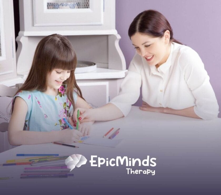 An ABA therapist smiles while guiding an autistic girl in drawing with colored pencils during ABA therapy.