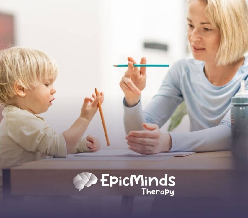 BCBA teaching toddler with autism to draw with pencils in ABA therapy.