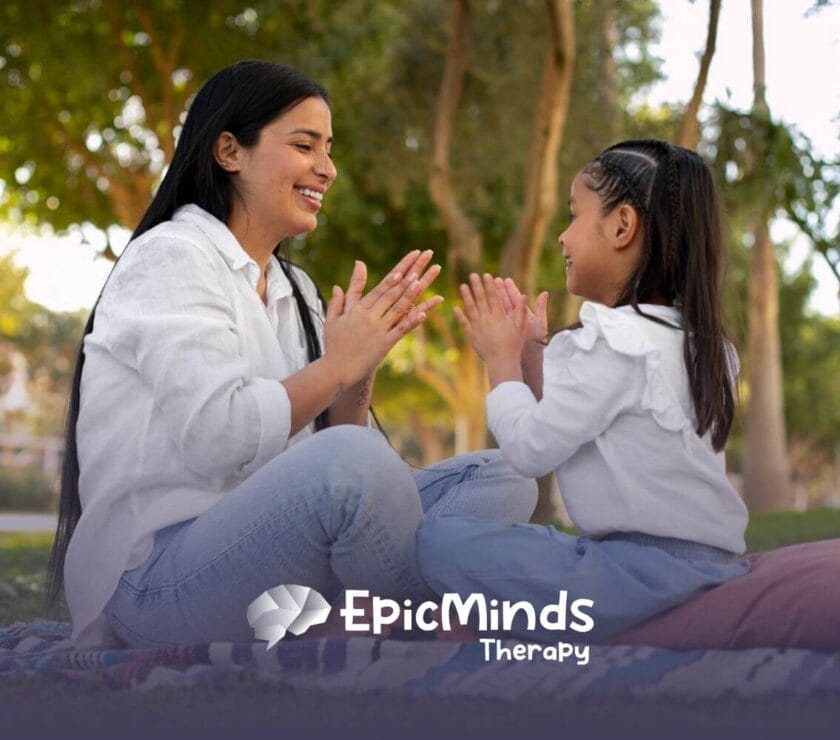 BCBA and girl with autism playing hand-clap game in the park.