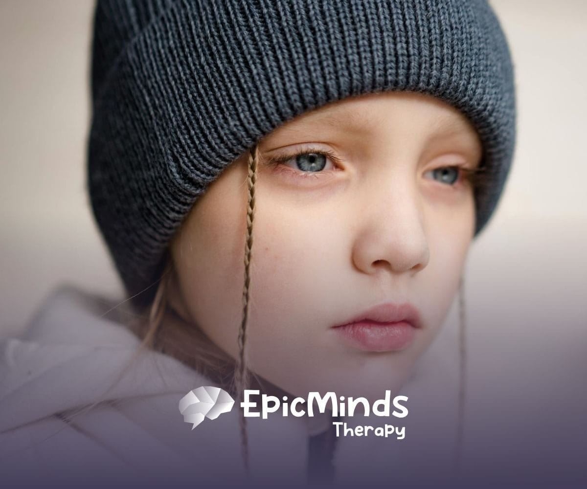 Close-up of an autistic child in a winter hat looking thoughtful outdoors in North Carolina.