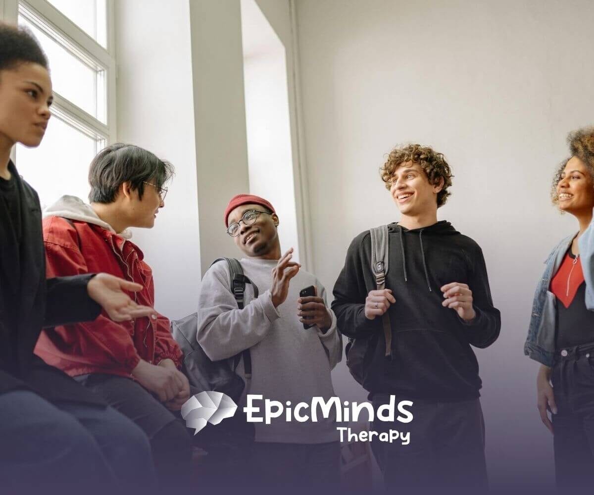 Group of autistic young adults chatting and laughing together indoors after their ABA therapy in North Carolina