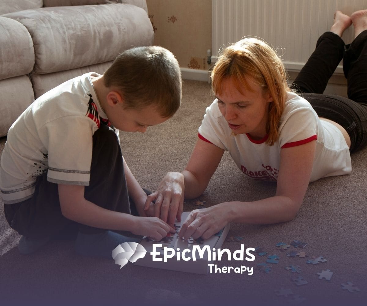 An ABA therapist and an autistic child are working together on a puzzle during in-home ABA therapy in NC.